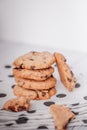 Piles of delicious chocolate chip cookies on a white plate with a milk bottle. Pastry utensils with white linen napkins on a woode Royalty Free Stock Photo