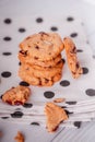 Piles of delicious chocolate chip cookies on a white plate with a milk bottle. Pastry utensils with white linen napkins on a woode Royalty Free Stock Photo