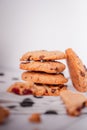 Piles of delicious chocolate chip cookies on a white plate with a milk bottle. Pastry utensils with white linen napkins on a woode Royalty Free Stock Photo