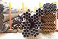 Piles of different pipes in outdoor warehouse