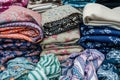 piles of folded hijabs in various patterns