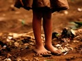 Piles of garbage and filth surrounding a foot child.. AI generation