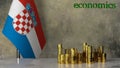 Piles of gold coins on a marble table against the background of the flag of Croatia.