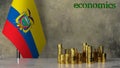 Piles of gold coins on a marble table against the background of the flag of Ecuador.