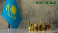 Piles of gold coins on a marble table against the background of the flag of Kazakhstan.