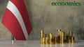 Piles of gold coins on a marble table against the background of the flag of Latvia.