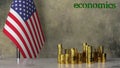 Piles of gold coins on a marble table against the background of the flag of USA.