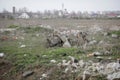 Piles of industrial and home waste lay on a field near inhabited houses