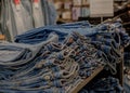 Piles of jeans on a counter in shop. Fashion and shopping concept Royalty Free Stock Photo