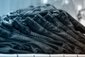 Piles of jeans on a shelf in a store, close-up, selective focus, front view, tinted blue. Shopping clothes concept Royalty Free Stock Photo