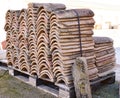 Piles of old roof tiles in many rows with different number in any column. The ancient tiles are stained with dust and lichens to Royalty Free Stock Photo