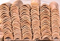 Piles of old roof tiles in many rows with different number in any column. The ancient tiles are stained with dust and lichens to Royalty Free Stock Photo