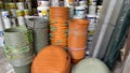 piles of orange and black plastic buckets and piles of paint cans