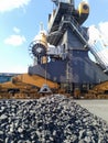 Piles of raw steel briquettes. Heap of coal anthracite in the port. Port cranes for coal loading Royalty Free Stock Photo