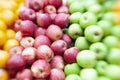 Piles of Red and Green Apples with Oranges