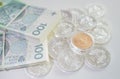 piles of silver ducats with one gold on them next to two piles of paper money next to each other clamped with an elastic Royalty Free Stock Photo