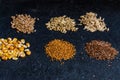 Piles of six different grains on black background
