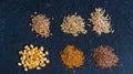 Piles of six different grains on black background