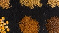 Piles of six different grains on black background