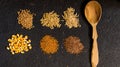 Piles of six different grains on black background