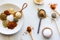 Piles of spices on various spoons and a plate with copy space in the middle. Royalty Free Stock Photo