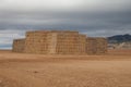 Piles of stacked rectangular straw bales in a farmland.