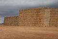 Piles of stacked rectangular straw bales in a farmland.