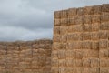Piles of stacked rectangular straw bales in a farmland.