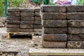 Piles of stone street tiles on pallets, paving industry background