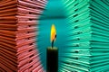 Piles of thick red and green book covers with brightly lit candles.