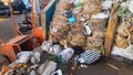 piles of vegetables in bamboo baskets and plastic bags in trash cans at traditional markets