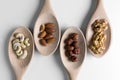 Piles of walnuts, ceshews, almond and hazelnuts in wooden spoones on white background. Nuts for health. Selective focus