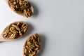 Piles of walnuts in wooden spoones on white background. Nuts for health. Selective focus.