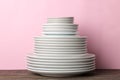 Piles of white ceramic tableware, plates, saucers, cups on a pink background. kitchenware Royalty Free Stock Photo