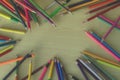 Piles of wood pencils on the floor, yellow desk in the art classroom