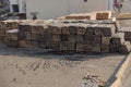 Piles of wooden planks at the seaport berth. Warehouse for sawing in stacks for loading in the open air. Material wooden wooden b