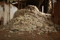 piles of wool piled up on the floors of an old traditional hard wood shearing shed waiting to be baled for the family farm, rural