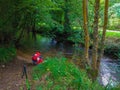 Pilgrim or backpacker drinking water from a river in middle of t Royalty Free Stock Photo