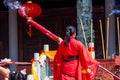 A pilgrim in a Chinese Buddhist temple offering incense