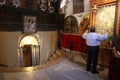 A pilgrim prays in front of the pictures of the Virgin with the Child Jesus, near the entrance to the cave of Jesus` birth, Bethle
