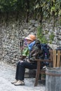 A pilgrim rests on a bench