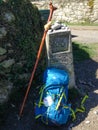 Pilgrim`s backpack leaning on a way marker, indicating the last 100km left to the city of Santiago d