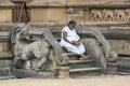 A pilgrim to the Kelaniya Raja Maha Vihara near Colombo in Sri Lanka sits on the steps to the shrine room.