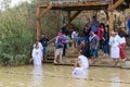 Pilgrims from different countries accept the rite of baptism in the Jordan River in Israel