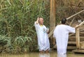 Pilgrims from different countries accept the rite of baptism in the Jordan River in Israel