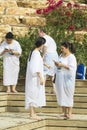 Pilgrims from different countries accept the rite of baptism in the Jordan River in Israel