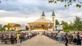 Pilgrims praying in pews before the holy mass in the outdoor shrine behind Saint James church