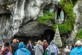 Pilgrims praying the statue of Virgin Mary in the grotto of Our Lady of Lourdes France Royalty Free Stock Photo