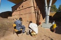 Pilgrims talk with the monolithic rock-hewn church at the background in Lalibela, Ethiopia.