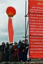 pilgrims are waiting next to a large chinese sign during a governmental announcement